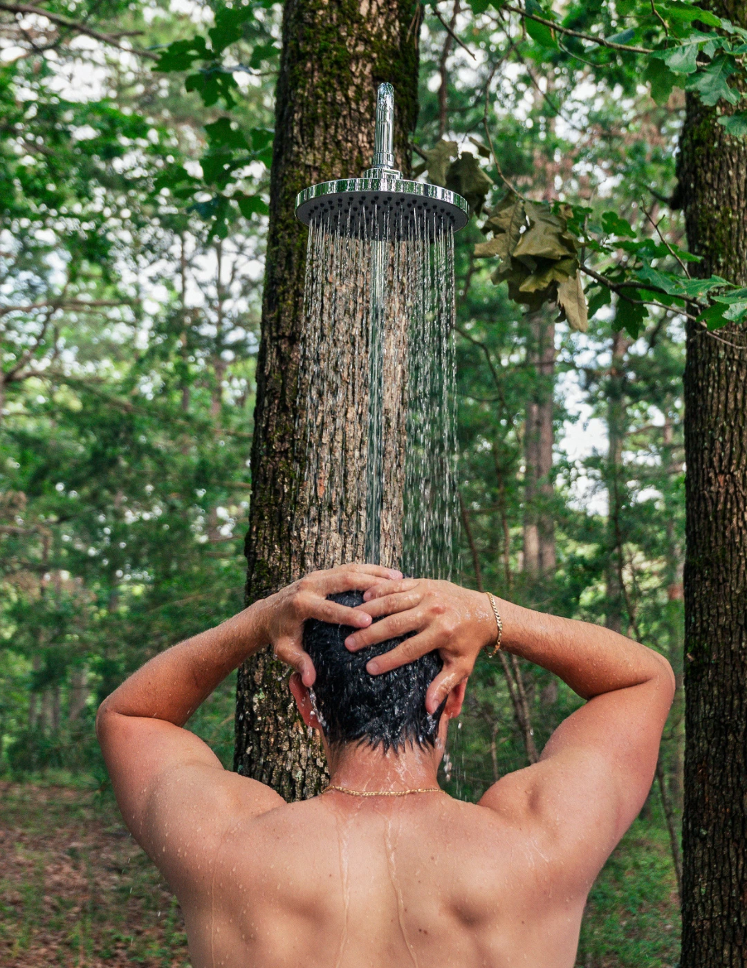 Guest using the outdoor shower in the forest