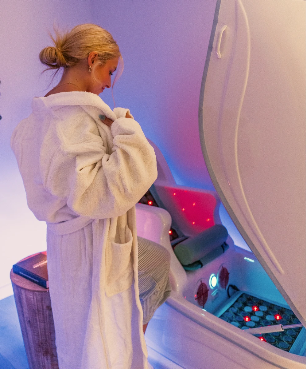 Guest in a plush robe preparing for a red light therapy session