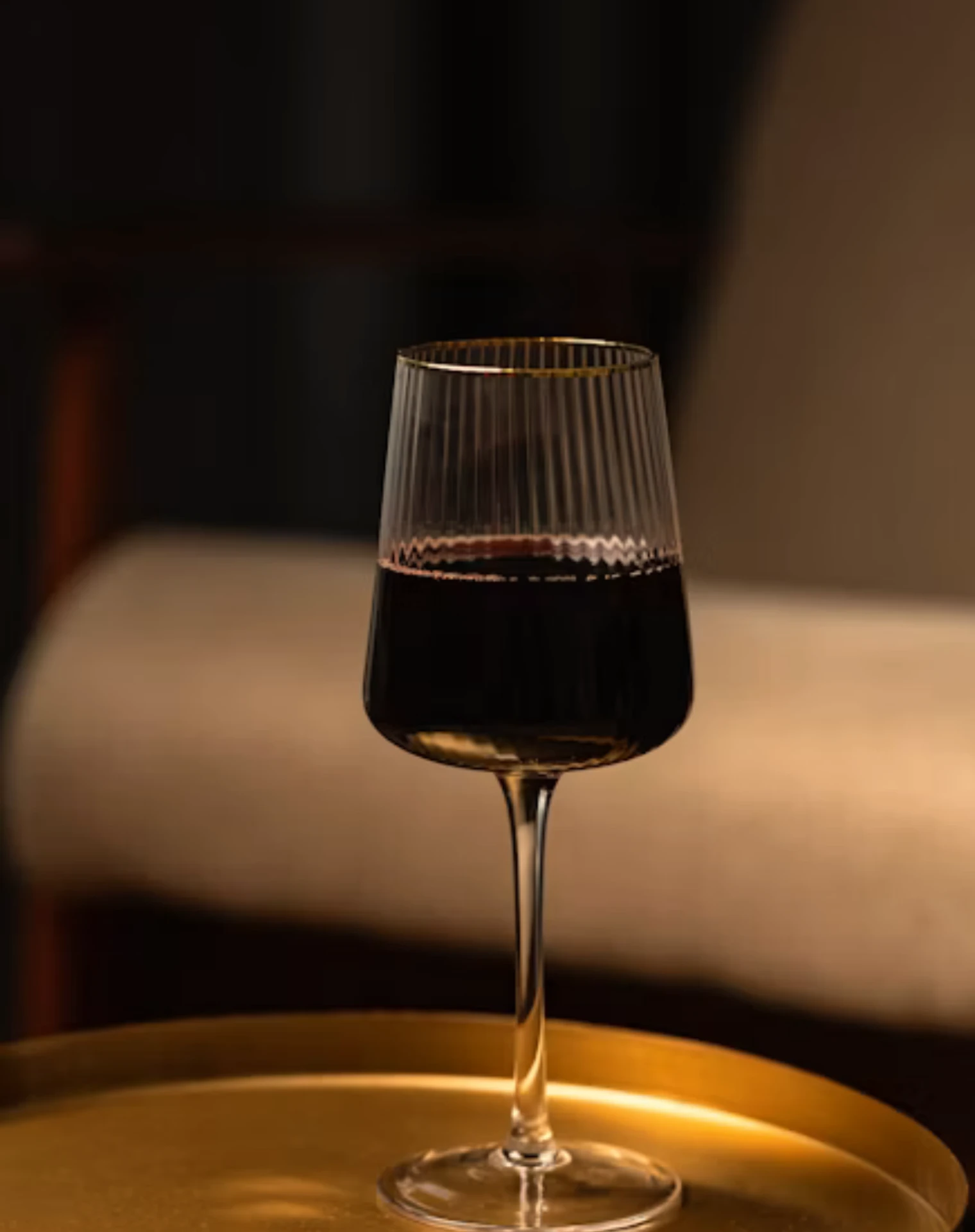 A glass of red wine on a brass side table