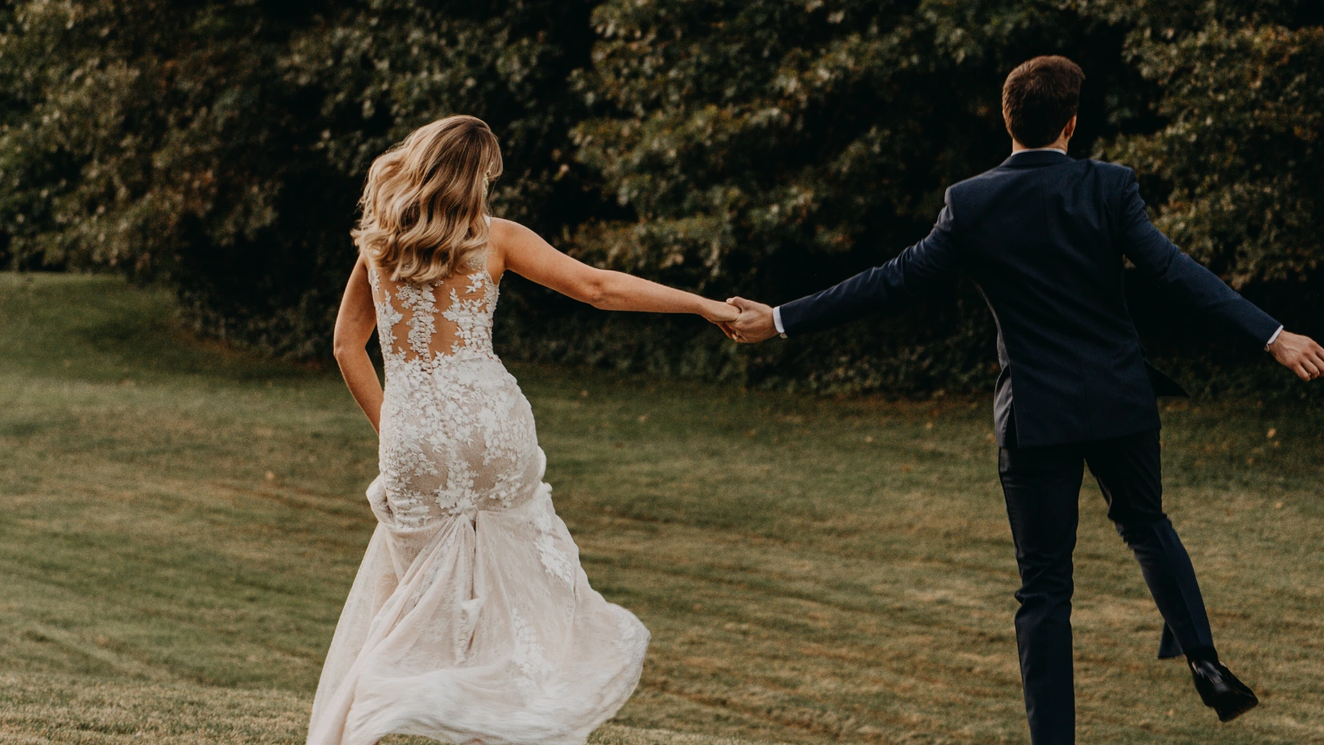 Bride and groom holding hands in the forest at Forest Springs