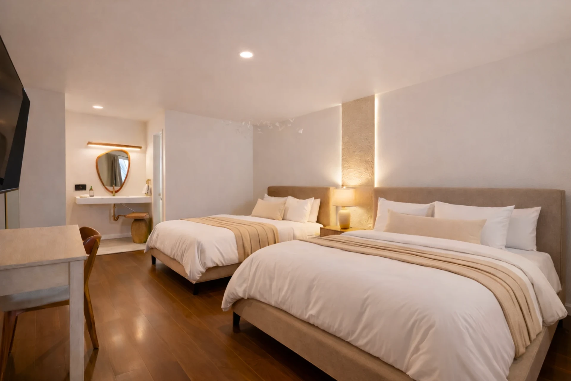 Double queen room with warm accent lighting and desk