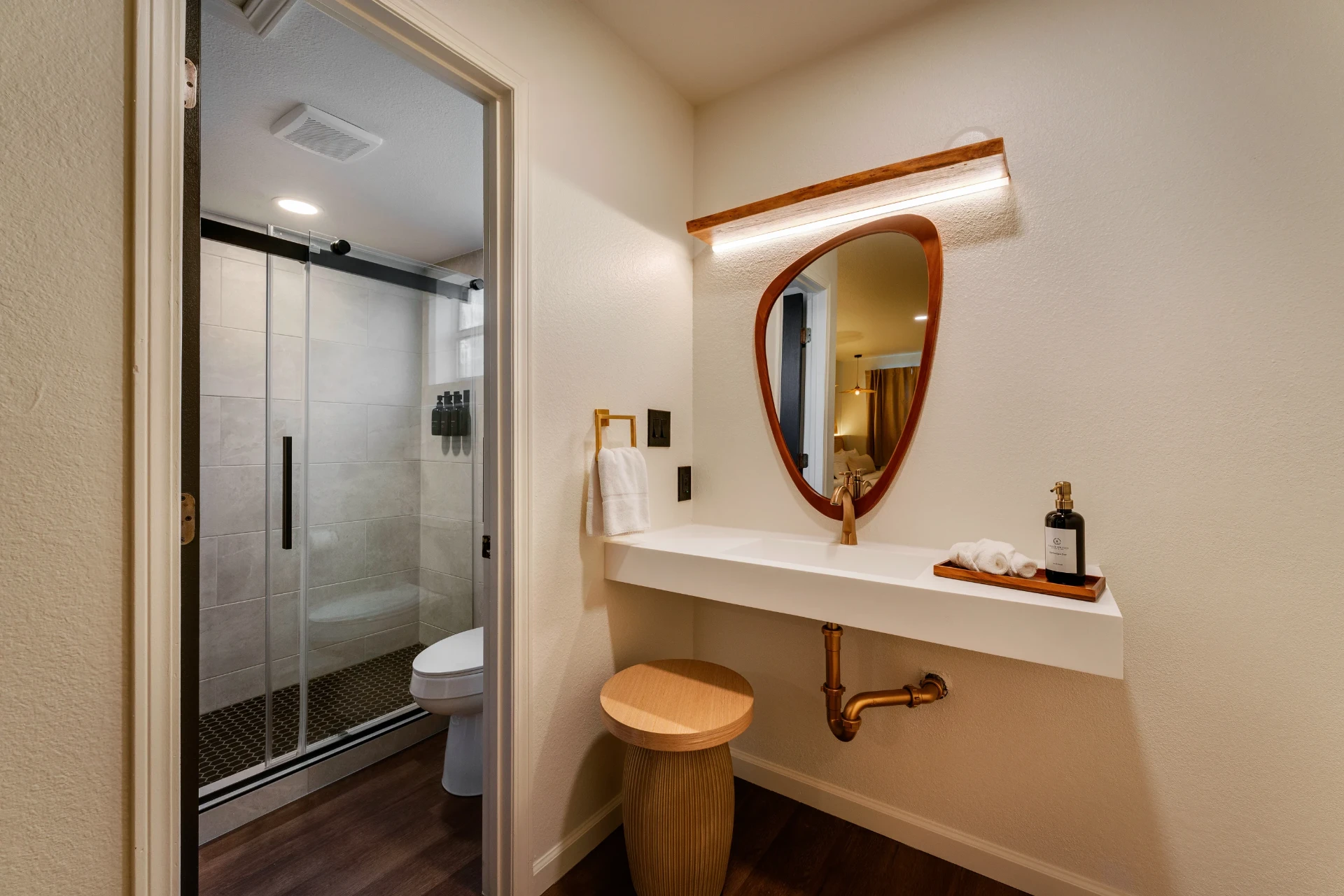 Bathroom vanity with organic mirror, brass fixtures and fresh towels