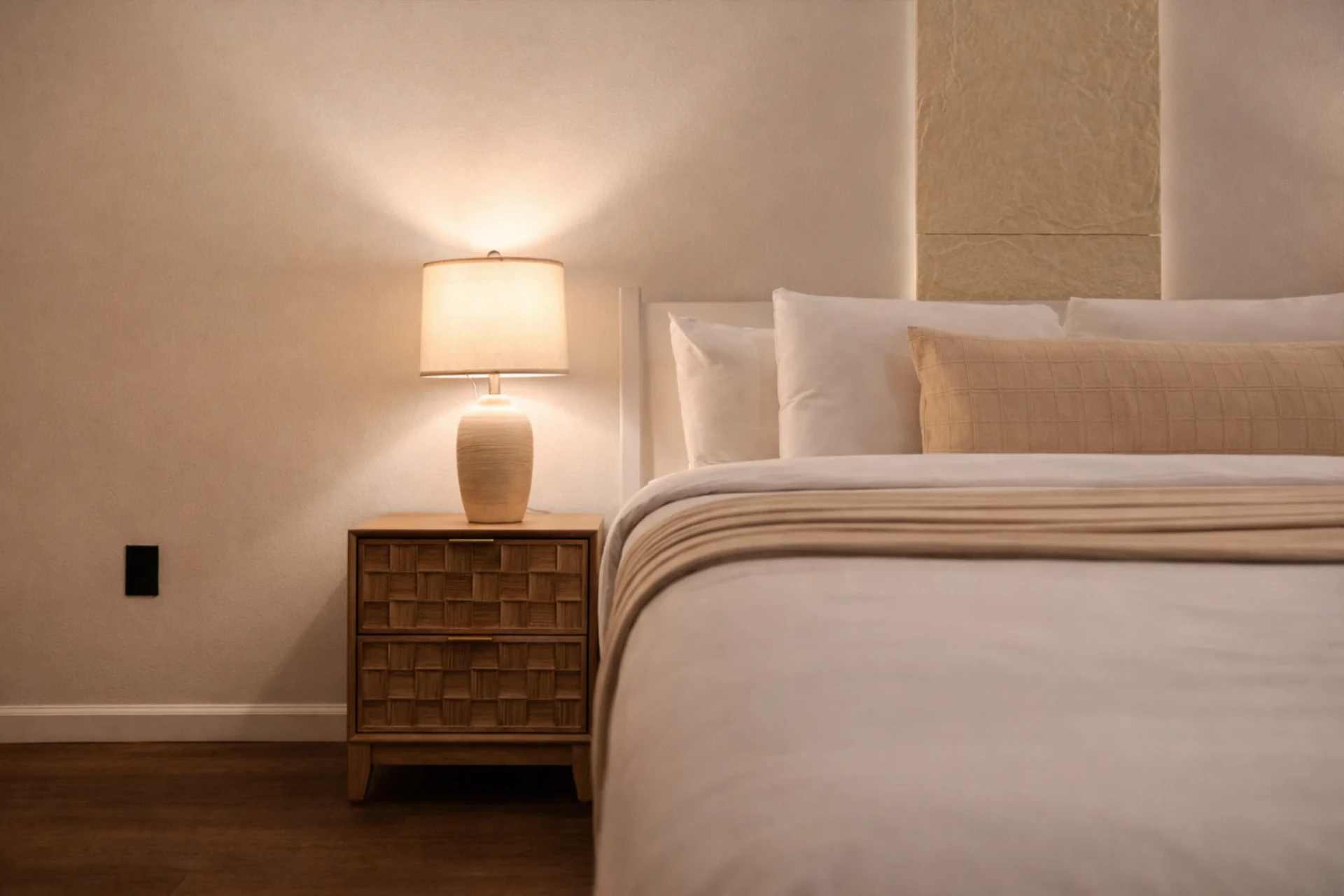 Woven nightstand and lamp beside the king bed