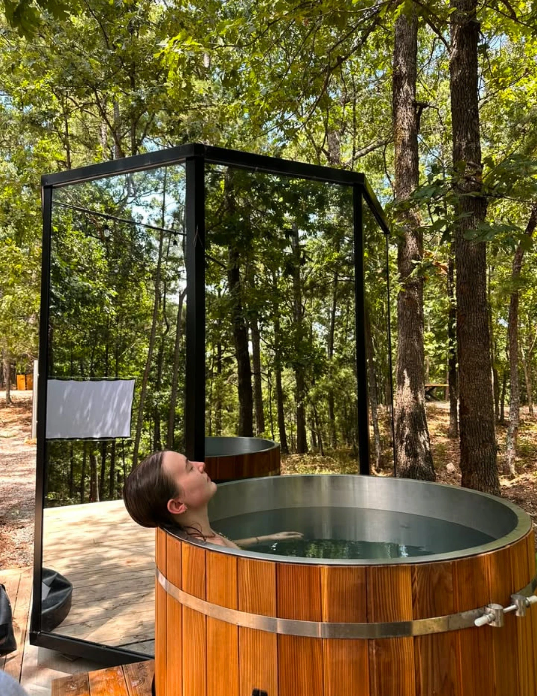 Guest enjoying the cold plunge beneath the forest canopy