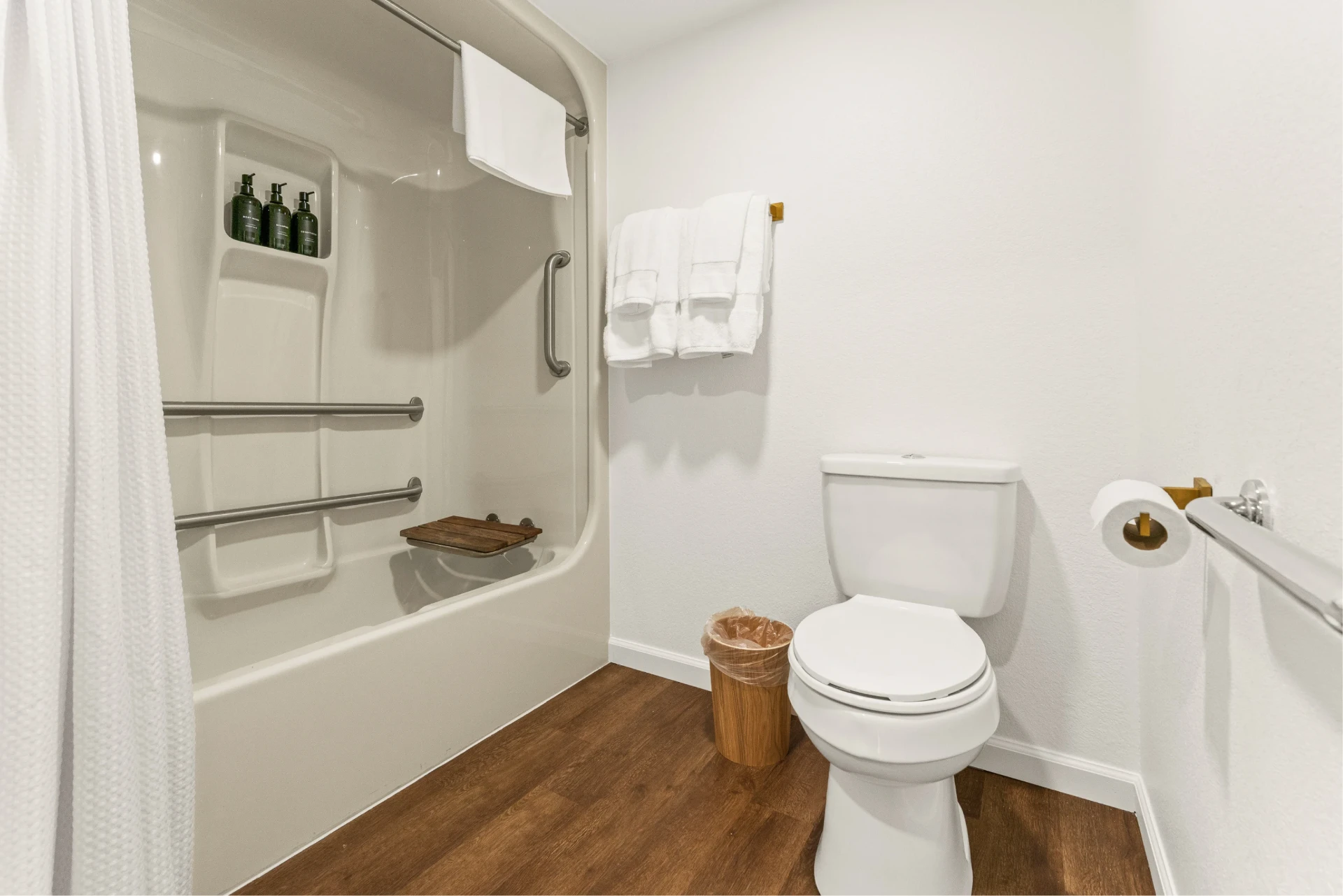 Accessible tub with grab bars, bench seat and white linens
