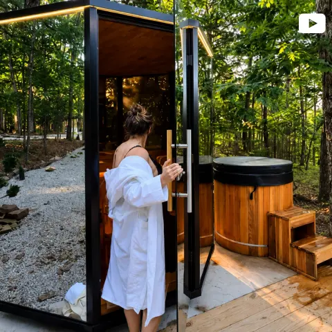 Guest in robe entering glass sauna by cold plunge