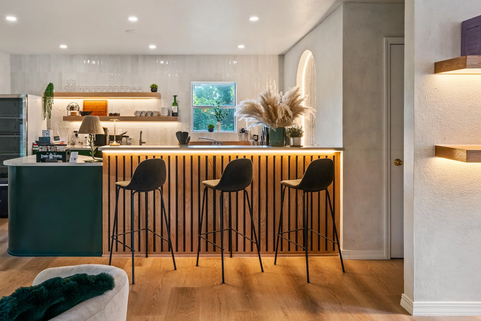 Coffee bar in the Forest Lounge at Forest Springs Resort with a slatted wood counter, warm under-lighting and black bar stools