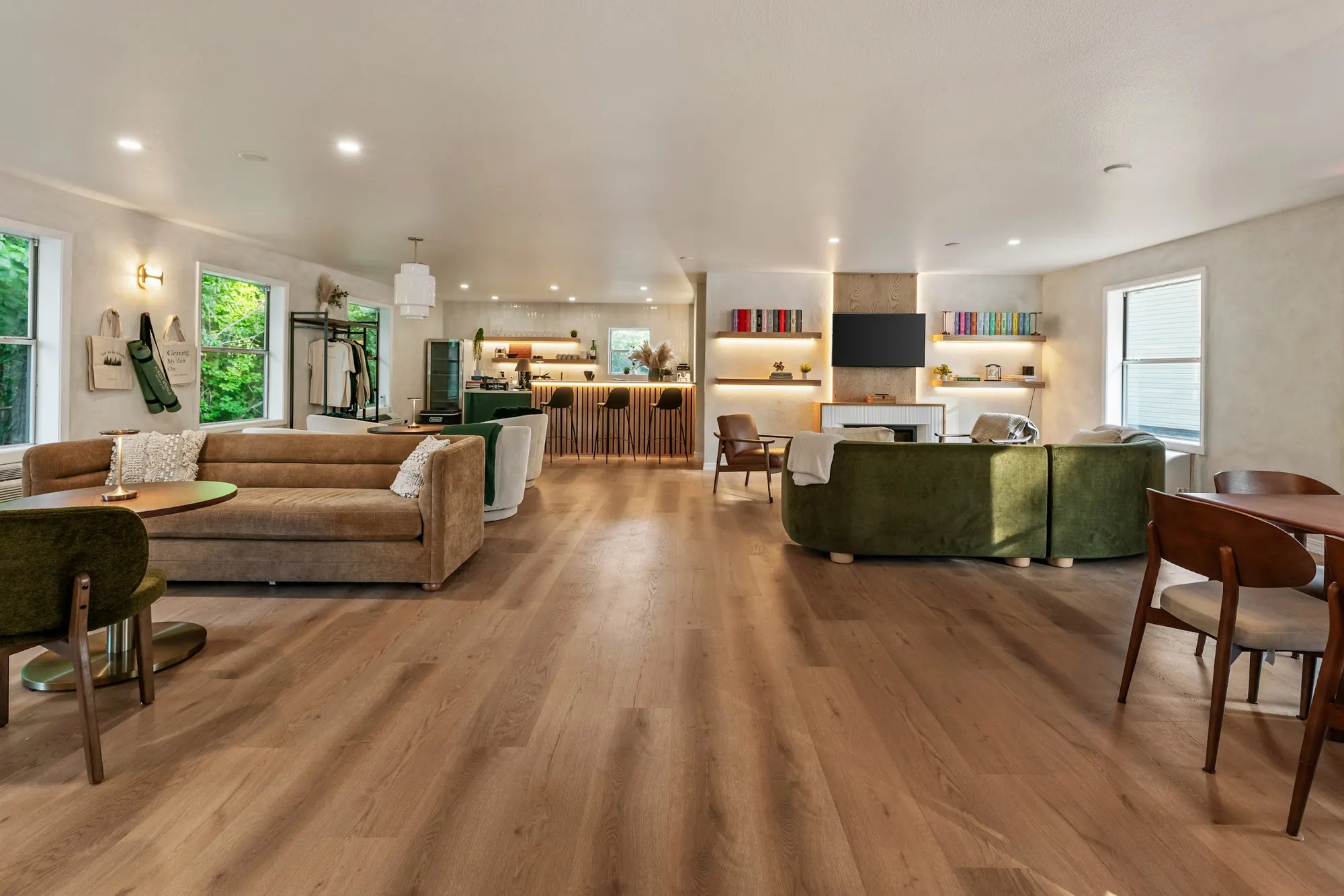 Wide view of the open-plan Forest Lounge at Forest Springs Resort in Eureka Springs: sofas, café tables, fireplace wall and coffee bar