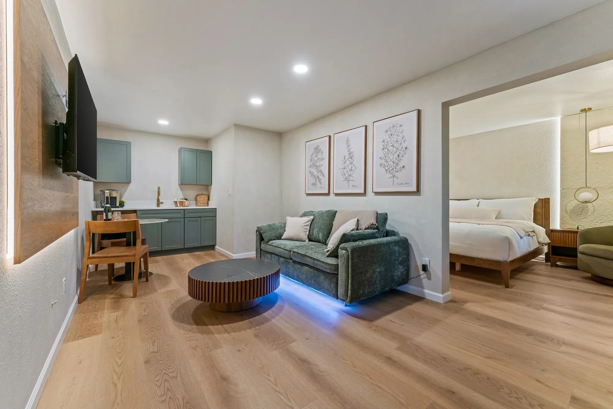 Suite at Forest Springs Resort with a green sofa, kitchenette and an open doorway to the bedroom