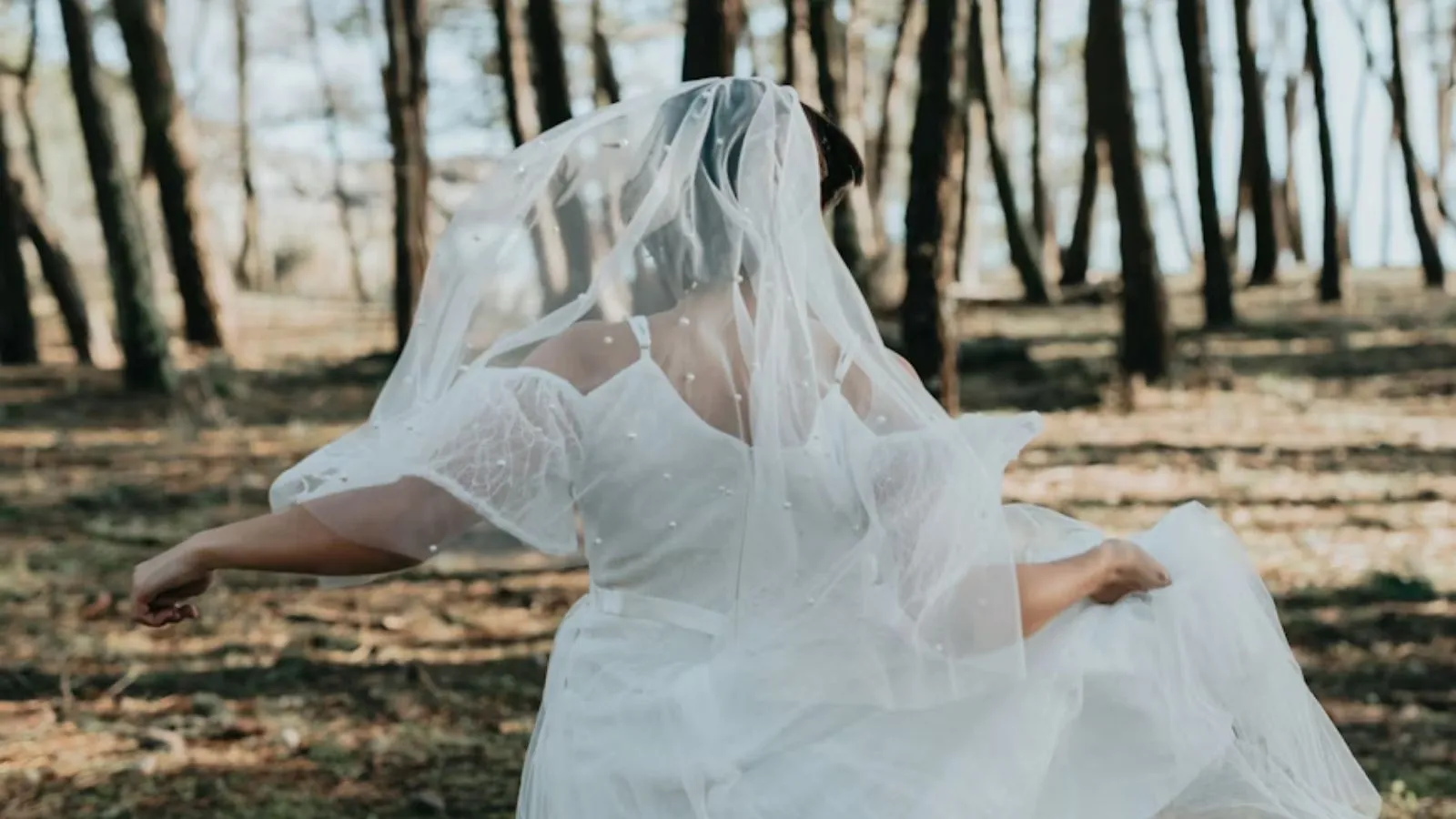 Bride walking through the forest at Forest Springs